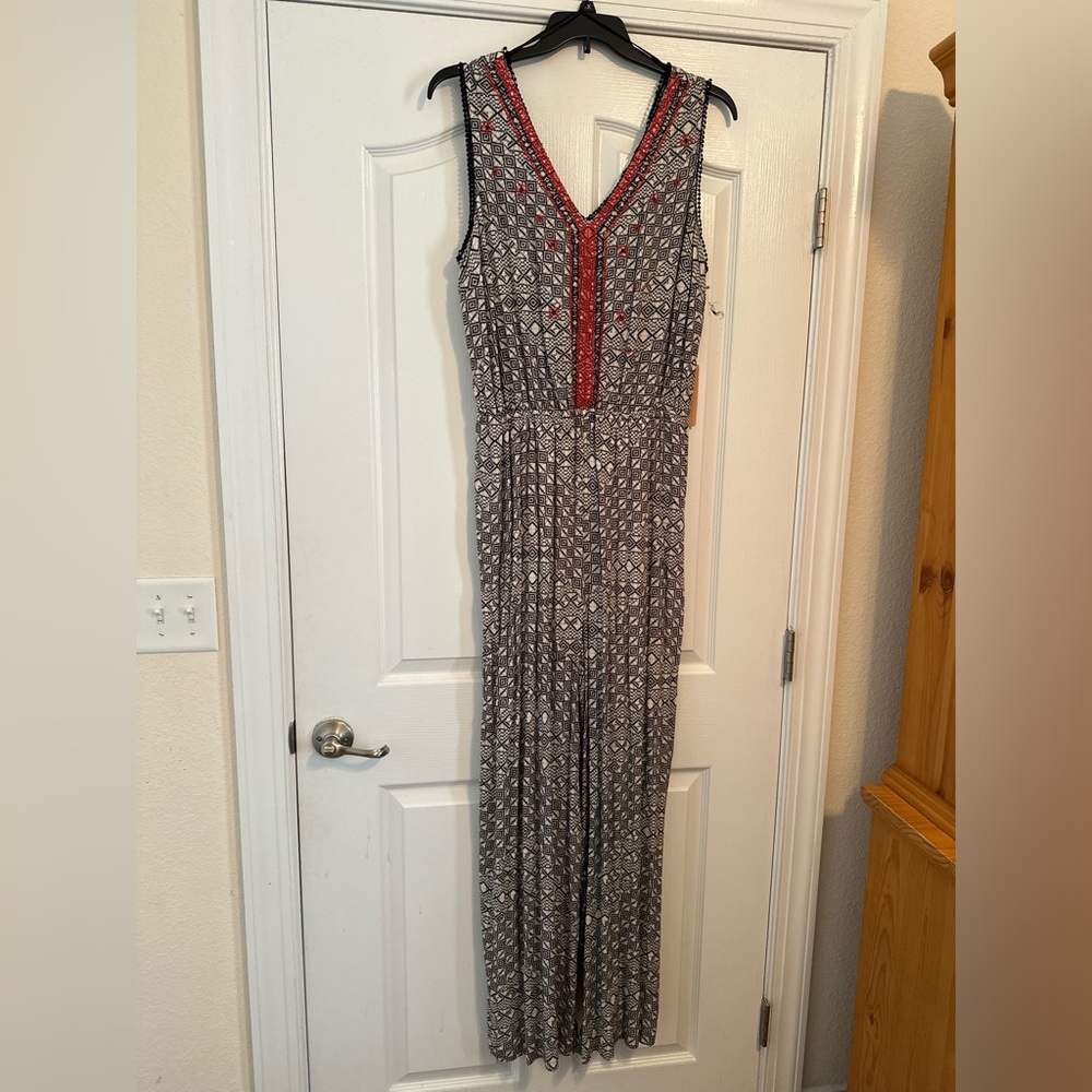 Black and white jumpsuit with red trim around the v neck